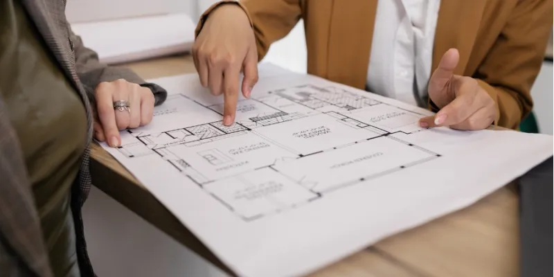 People looking at home remodeling blueprints.