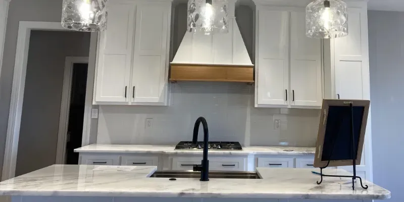 Remodeled kitchen with cabinets and marble countertop.