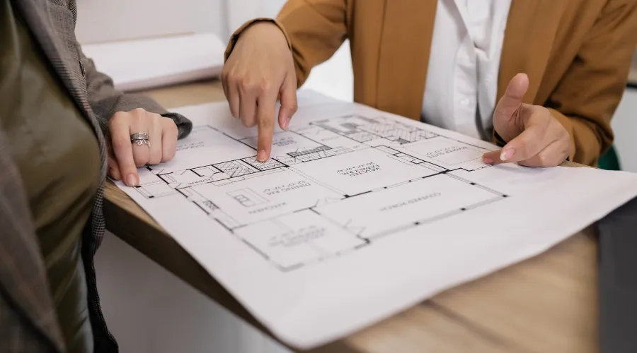 People looking at home remodeling blueprints.
