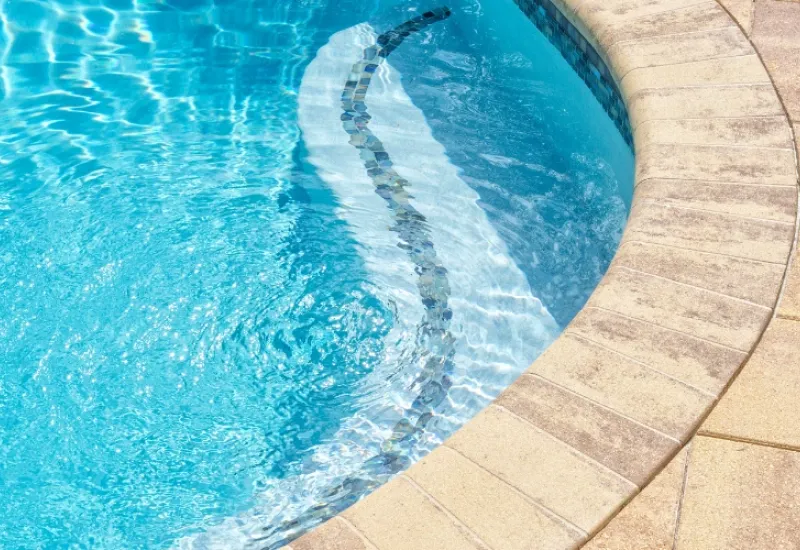 A pergola built for an outdoor spa on paver bricks.