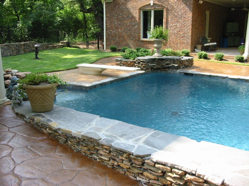 Pool with decorative concrete deck and natural stone accent.